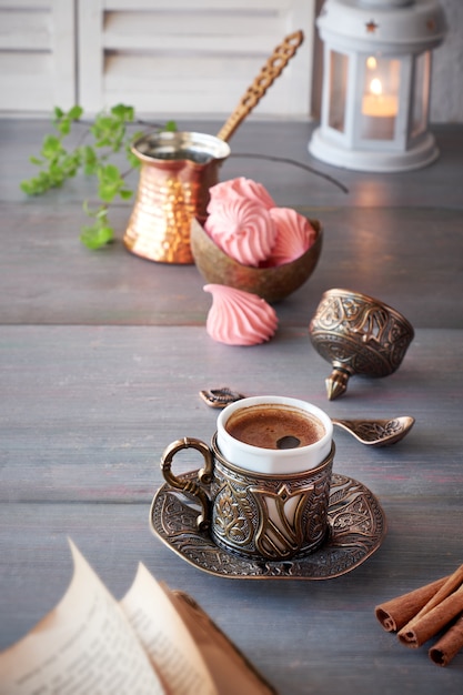 Orientalischer Kaffee, der in einer traditionellen türkischen Kaffeekanne aus Kupfer gekocht und in einer passenden Tasse serviert wird