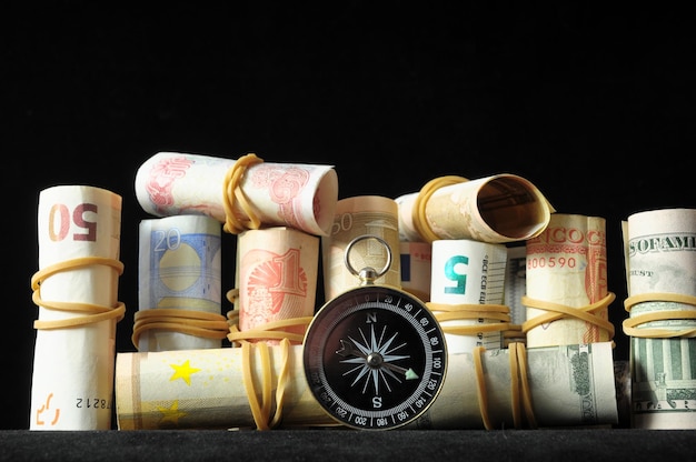 Foto orientierung im geschäftskompass und geld auf schwarzem hintergrund