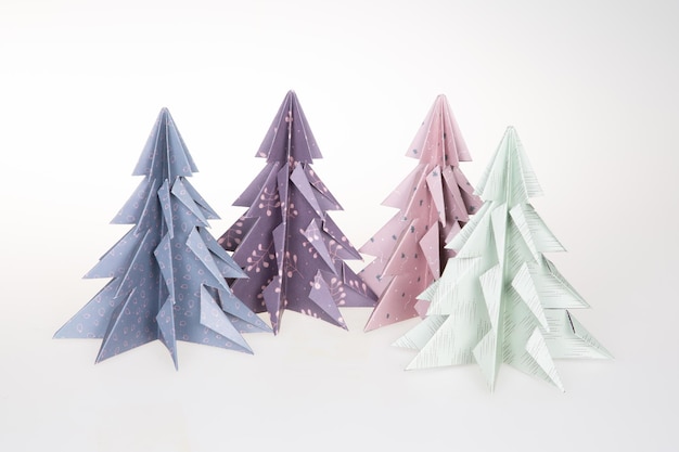Origami 3D Xmas tree cuatro de papel sobre fondo blanco Feliz Navidad Tarjeta de Año Nuevo en estilo Paper art