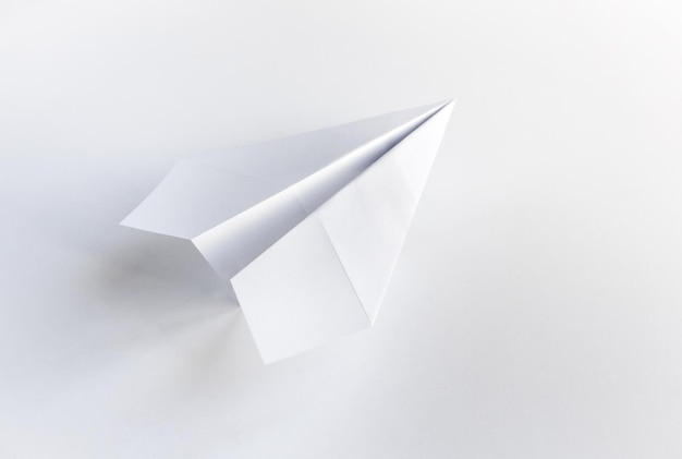 Origami de avión de papel aislado en un fondo blanco