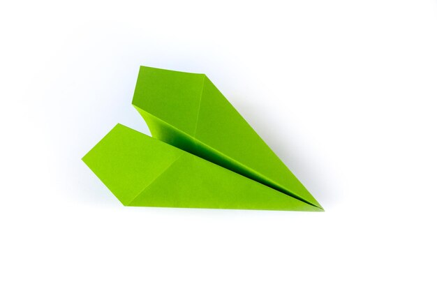 Origami de avión de papel verde aislado en un fondo blanco