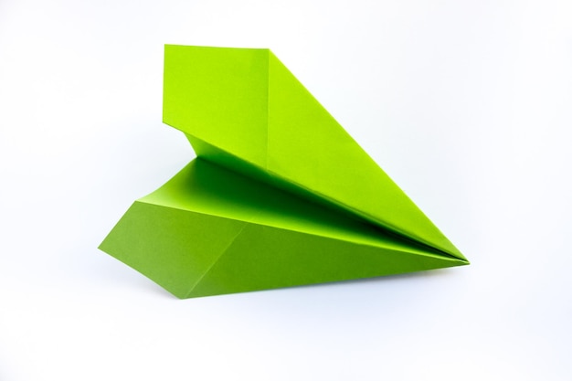 Origami de avión de papel verde aislado en un fondo blanco