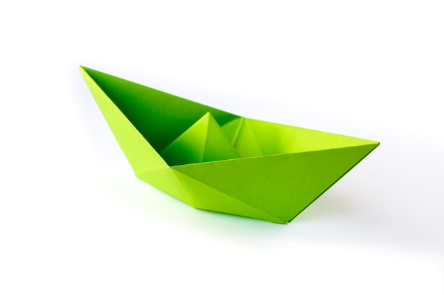 Origami de barco de papel verde aislado en un fondo blanco