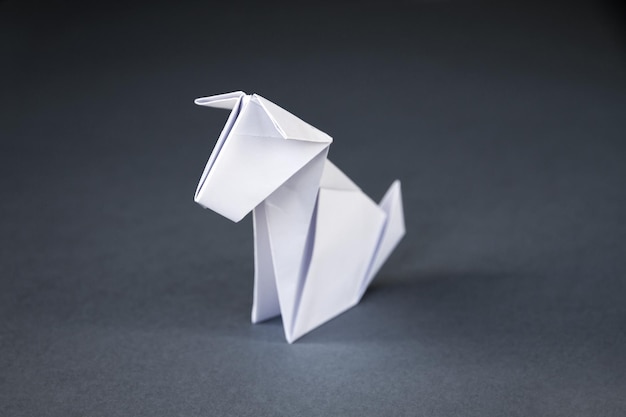 Origami de cachorro de papel branco isolado em um fundo cinza