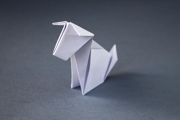 Origami de cachorro de papel branco isolado em um fundo cinza