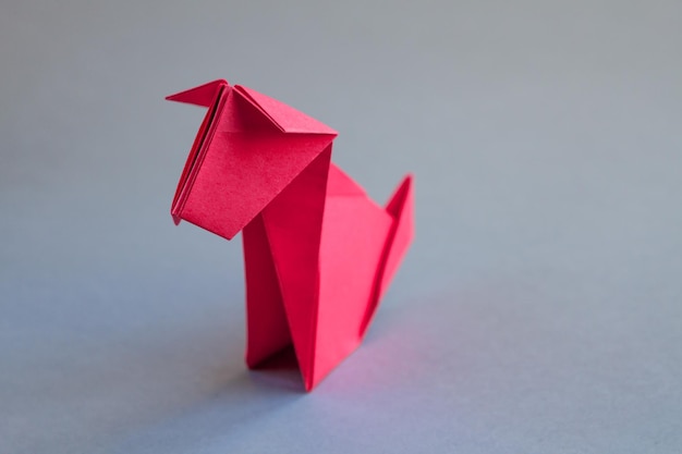 Origami de cachorro de papel vermelho isolado em um fundo cinza