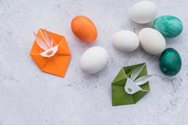 Origami de coelhos verdes e laranja e ovos de páscoa