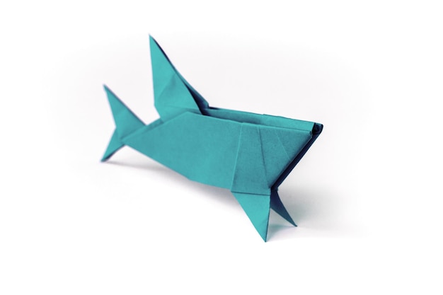 Origami de tubarão de papel azul isolado em um fundo branco