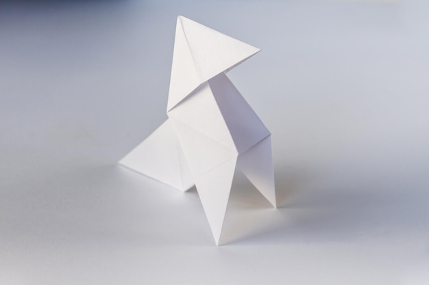 Origami de gallina de papel aislado en un fondo blanco