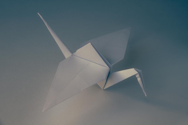 Origami de grúa de papel blanco aislado sobre fondo blanco