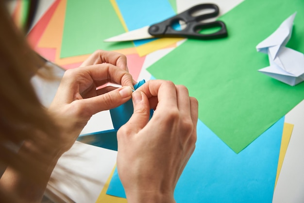 Foto origami-lektionen frau macht origami-osternkaninchen aus farbpapier diy-konzept