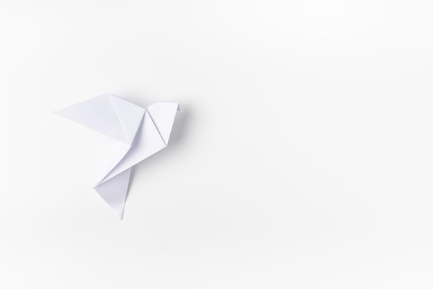 Origami de paloma blanca como símbolo de paz en un fondo blanco
