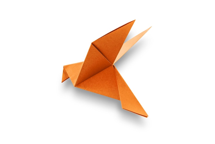 Foto origami de paloma de papel naranja aislado sobre un fondo blanco