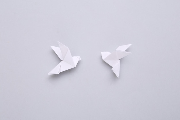 Origami-Papier gefaltete Tauben auf grauem Hintergrund Minimalismus-Friedenssymbol