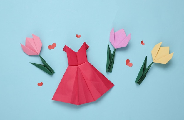 Origami-Papier rotes Kleid mit Herz Tulpe auf blauem Hintergrund Frühlingskomposition