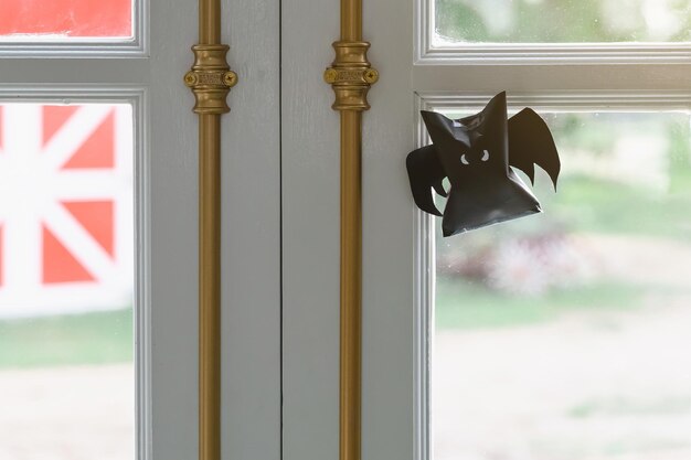 Foto origami-schläger aus schwarzem papier, das an einem seil für halloween-dekorationen hängt