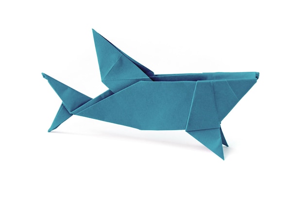 Origami de tiburón de papel azul aislado en un fondo blanco