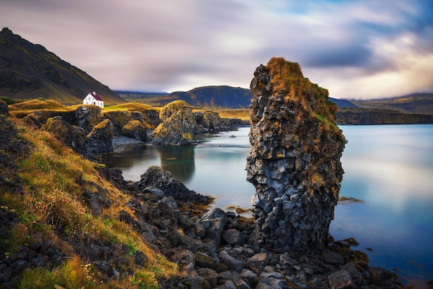 Orilla del mar en Islandia con acantilados y una pequeña casa en el pueblo de Arnarstapi