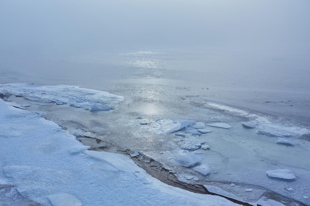 Orilla del río después de una nevada en un día nublado de invierno