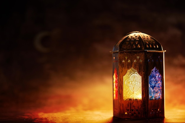 Ornamentelle arabische Laterne mit brennender Kerze, die nachts leuchtet