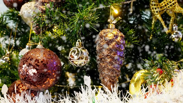 Foto ornamento cono dorado en el fondo del árbol de navidad feliz navidad y felices fiestas marco de tarjetas de felicitación banner año nuevo conceptos temáticos de vacaciones de invierno