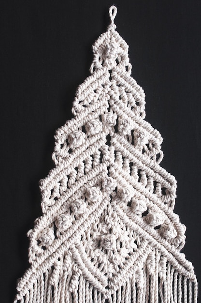 Foto ornamento de árvore de natal macrame de fios brancos de algodão natural sobre fundo preto