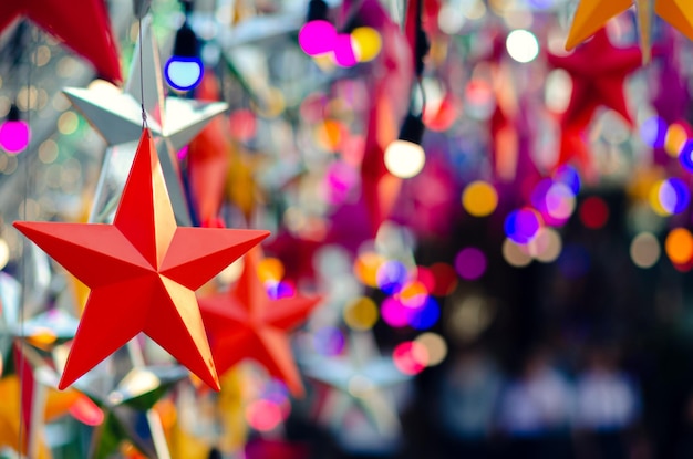 Ornamentos de estrellas coloridas colgando para decorar las vacaciones de Navidad