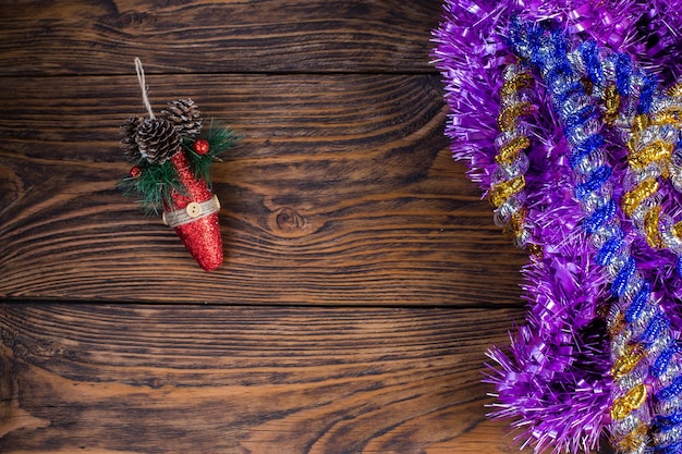 Oropel navideño y juguete rojo en el fondo de una vieja mesa de madera marrón