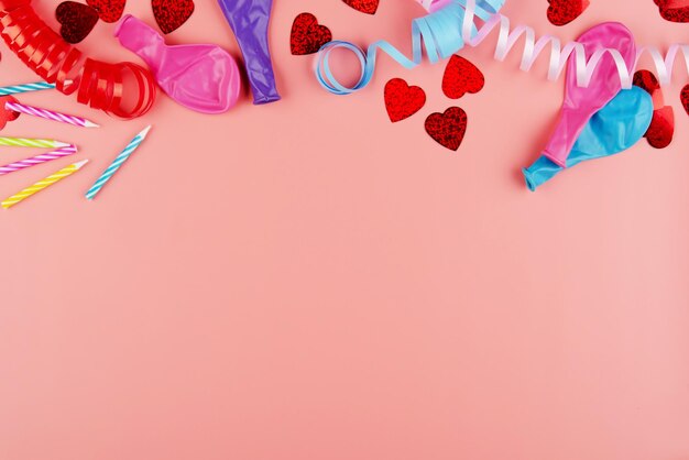 Oropel de preparación de aniversario festivo con globos y velas sobre fondo rosa Espacio para texto