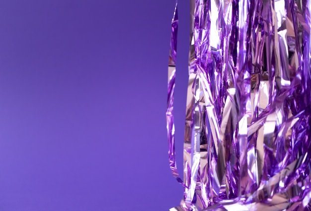 Oropel de vacaciones púrpura sobre fondo violeta, horizontal. Telón de fondo creativo