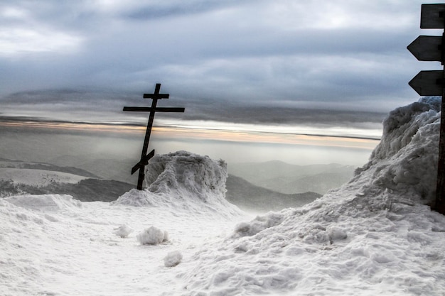 Orthodoxes Kreuz in schneebedeckten Bergen