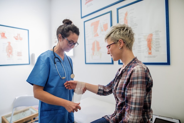 Orthopäde hilft dem Patienten.