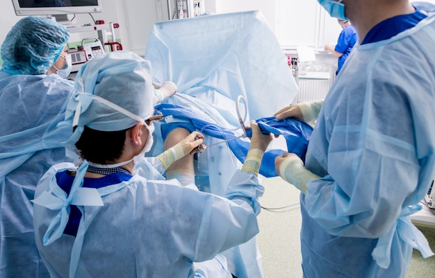 Orthopäden in Teamarbeit im Operationssaal mit modernen arthroskopischen Werkzeugen.