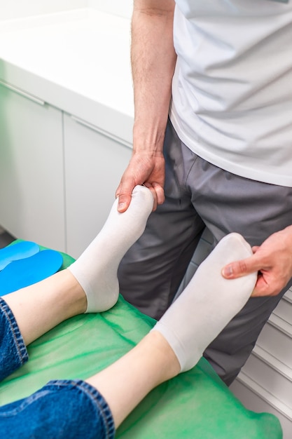 Orthopädische Einlegesohle. Der Orthopäde arbeitet mit dem Patienten. Orthopädische Klinik. Wahl der Einlagen in einer orthopädischen Klinik. Der Orthopäde bietet dem Patienten die Einlage an Fußpflege