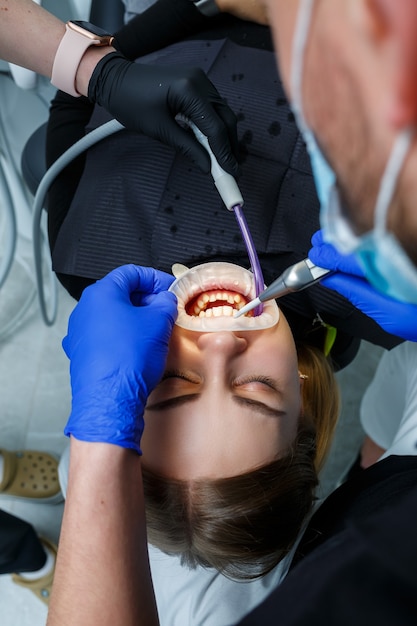 El ortodoncista coloca aparatos de ortodoncia en los dientes del paciente. Tratamiento dental de ortodoncia. Foto de alta calidad