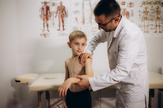 Foto el ortopedista examina a los niños de cerca en la clínica el tratamiento de la escoliosis