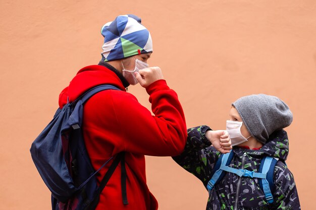 Os alunos com máscaras protetoras se cumprimentam com os cotovelos