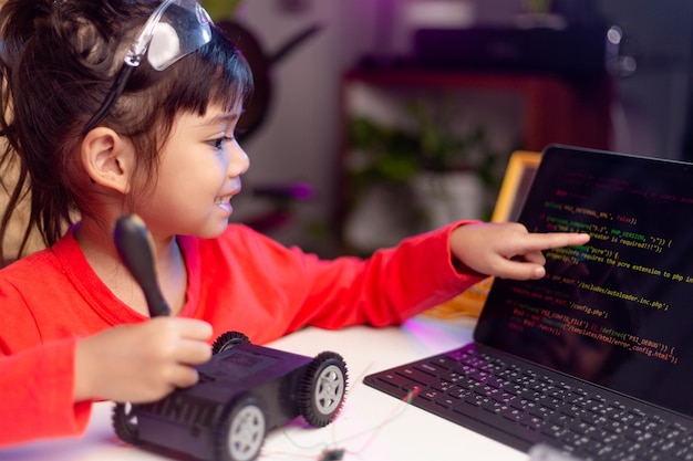 Os alunos da ásia aprendem em casa na codificação de carros robóticos e cabos de placas eletrônicas em stem steam matemática engenharia ciência tecnologia código de computador em robótica para crianças conceito