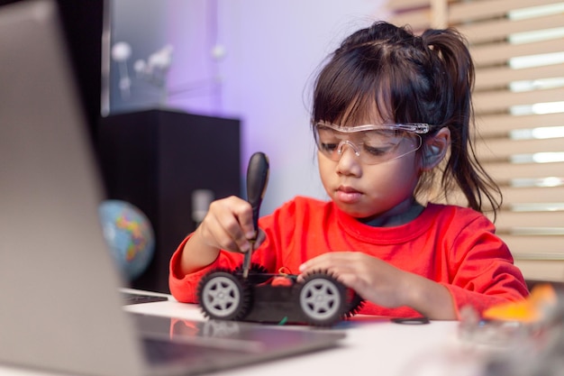 Os alunos da ásia aprendem em casa na codificação de carros robóticos e cabos de placas eletrônicas em stem steam matemática engenharia ciência tecnologia código de computador em robótica para crianças conceito