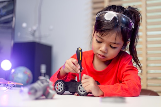 Os alunos da Ásia aprendem em casa na codificação de carros robóticos e cabos de placas eletrônicas em STEM STEAM matemática engenharia ciência tecnologia código de computador em robótica para crianças conceito