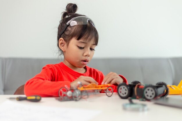 Os alunos da Ásia aprendem em casa na codificação de carros robóticos e cabos de placas eletrônicas em STEM STEAM matemática engenharia ciência tecnologia código de computador em robótica para crianças conceito