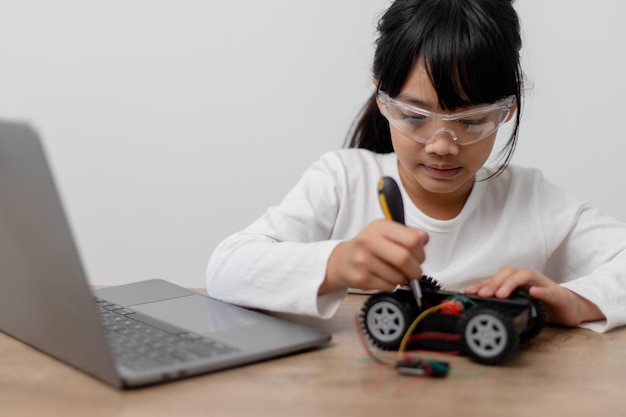 Os alunos da Ásia aprendem em casa na codificação de carros robóticos e cabos de placas eletrônicas em STEM STEAM matemática engenharia ciência tecnologia código de computador em robótica para crianças conceito