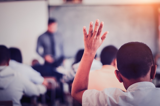 Os alunos estão levantando as mãos para pedir aos professores