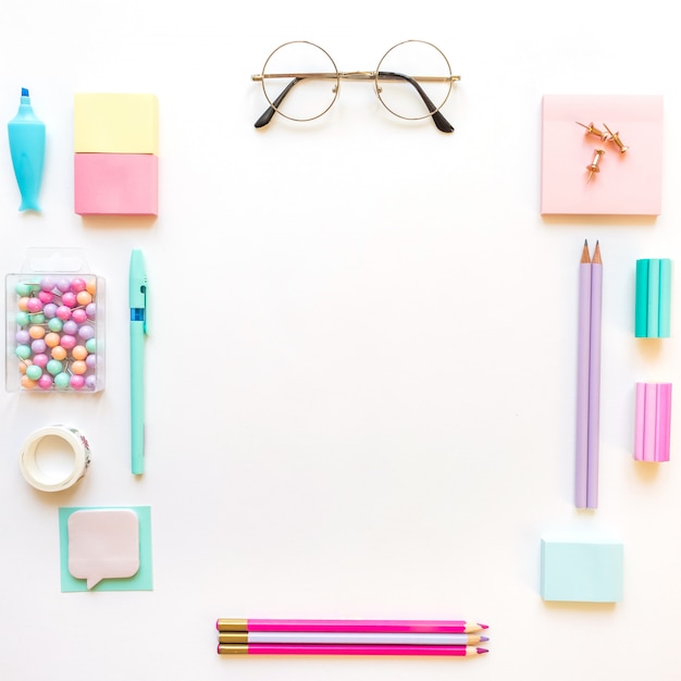 Foto os artigos de papelaria, menina ajustaram-se em máscaras pastel no fundo branco.