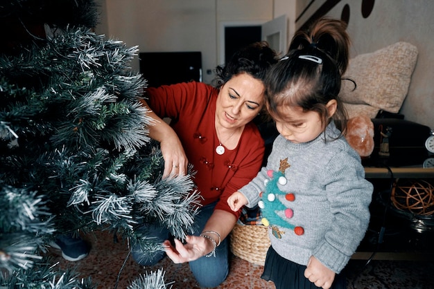 Foto os avós decoram a árvore de natal com a neta