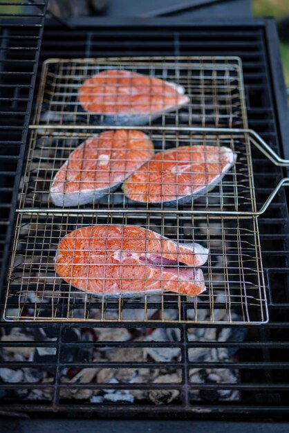 Foto os bifes de salmão à grelha estão a cozinhar na lenha no quintal.