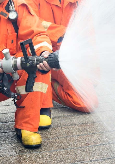 Os bombeiros borrifam água para parar um incêndio