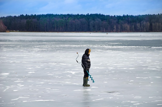 Os bravos homens no gelo para a pesca de inverno