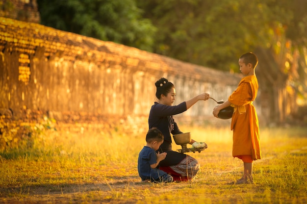 Os budistas estão fazendo mérito de acordo com os princípios do budismo pela manhã, levando comida aos monges que os monges abençoarão.