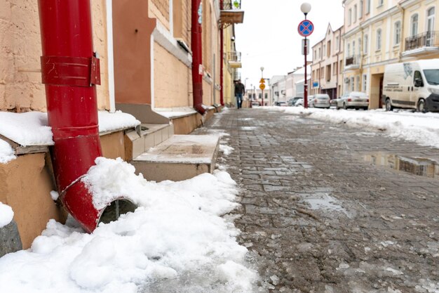 Os canos estão cobertos de gelo e neve Depois de uma forte tempestade de neve a cidade fica coberta de neve e gelo Há muitos pingentes de gelo na fachada do edifício Gelo nas calçadas e estradas